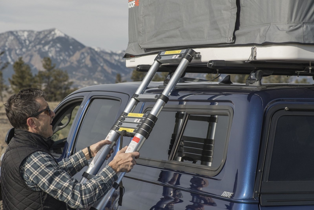 man attaching roofnest ladder to rooftop tent sparrow